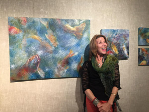 photo of Nanci Hersh in front of her ptgs. at Blue Streak gallery.
